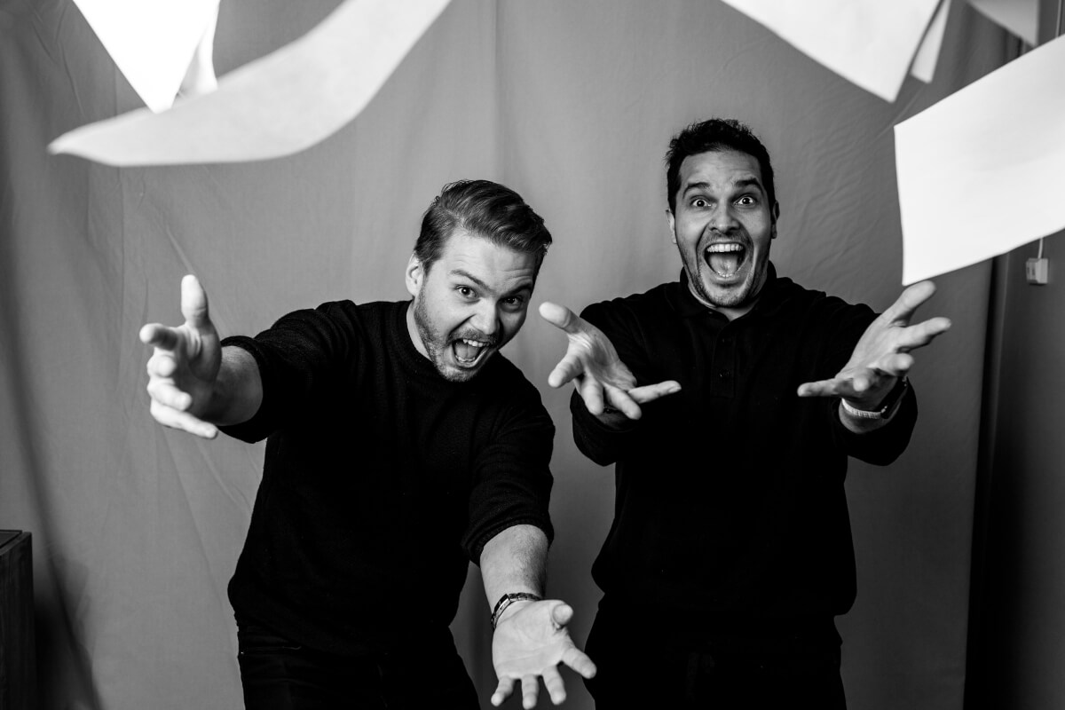 Two team members mid-throw, papers flying