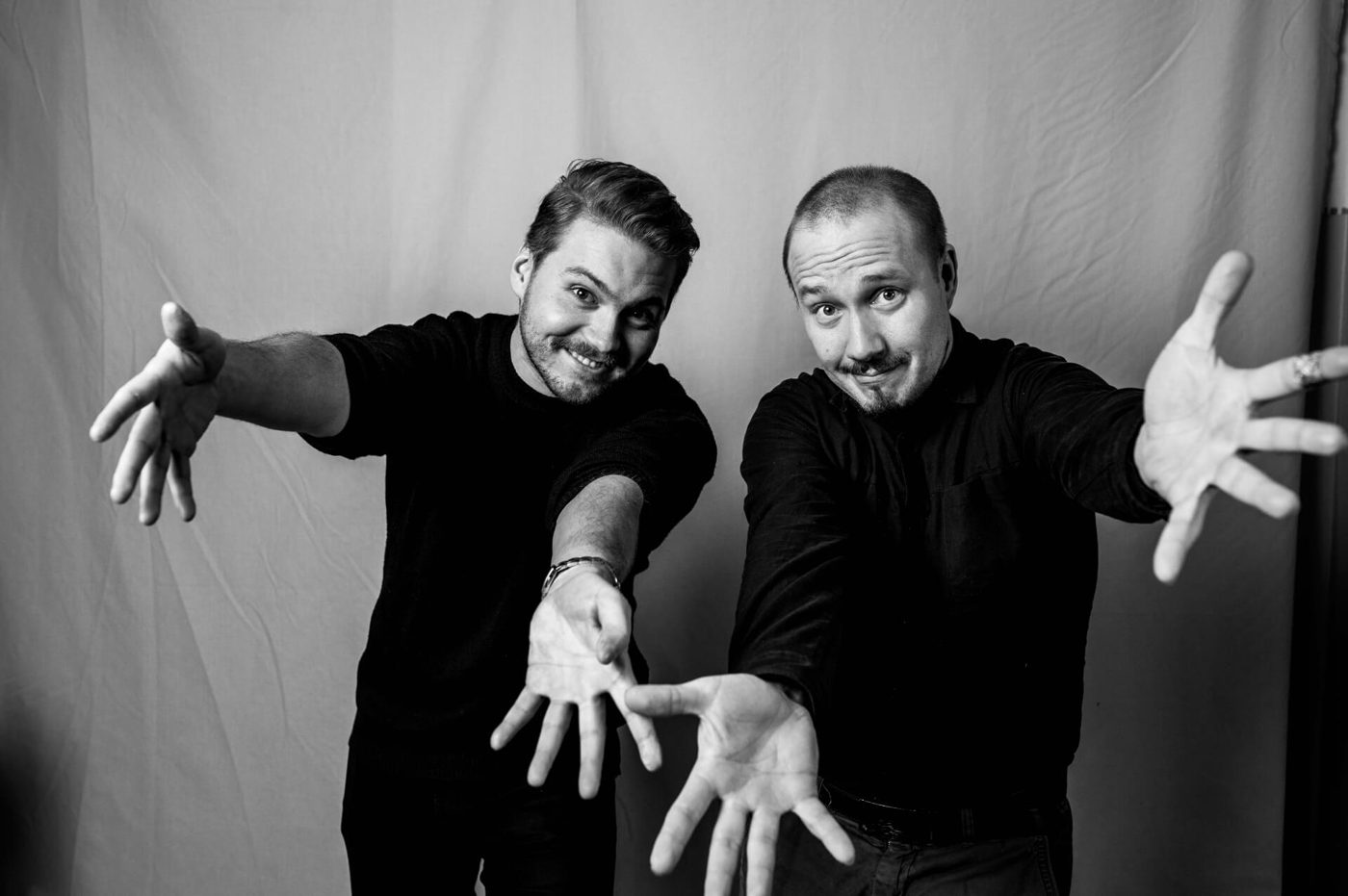 Two team members reaching toward the camera